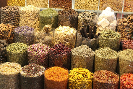 Un étal au marché qui vend des épices, des légumes, et des céréales